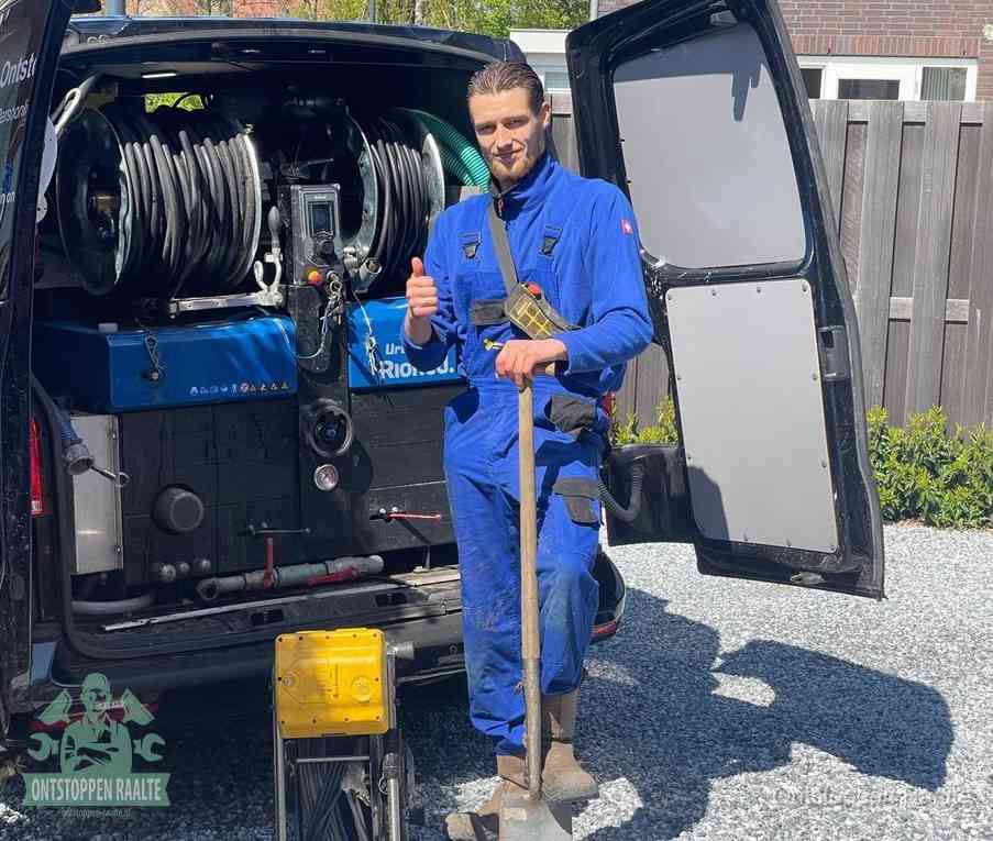 Een tevreden monteur met opgestoken duim naast de bestelbus, slim ingrijpen bespaart kosten bij een verstopte afvoer in Raalte