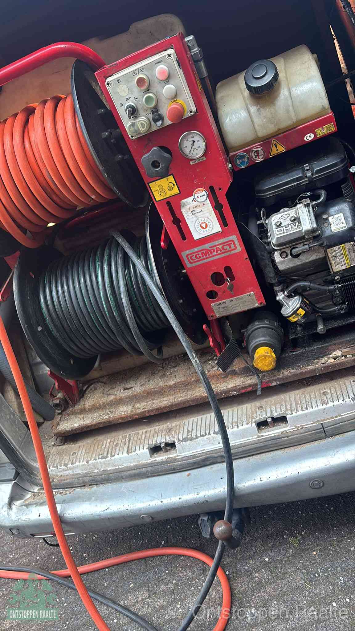 Een rood hogedruk-rioolreinigingstoestel in de laadbak van de bedrijfsbus, apparatuur voor een hardnekkige afvoerverstopping in Raalte