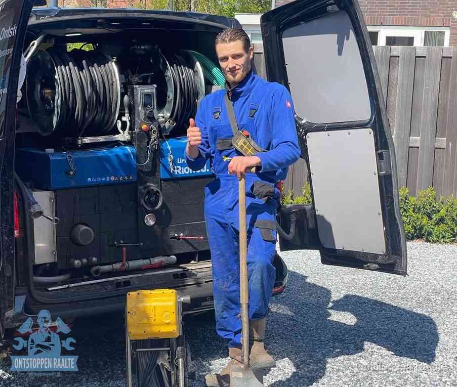 Een monteur bij de werkbus met grote hogedruk-slanghaspels, apparatuur voor hardnekkige afvoerverstoppingen in Raalte