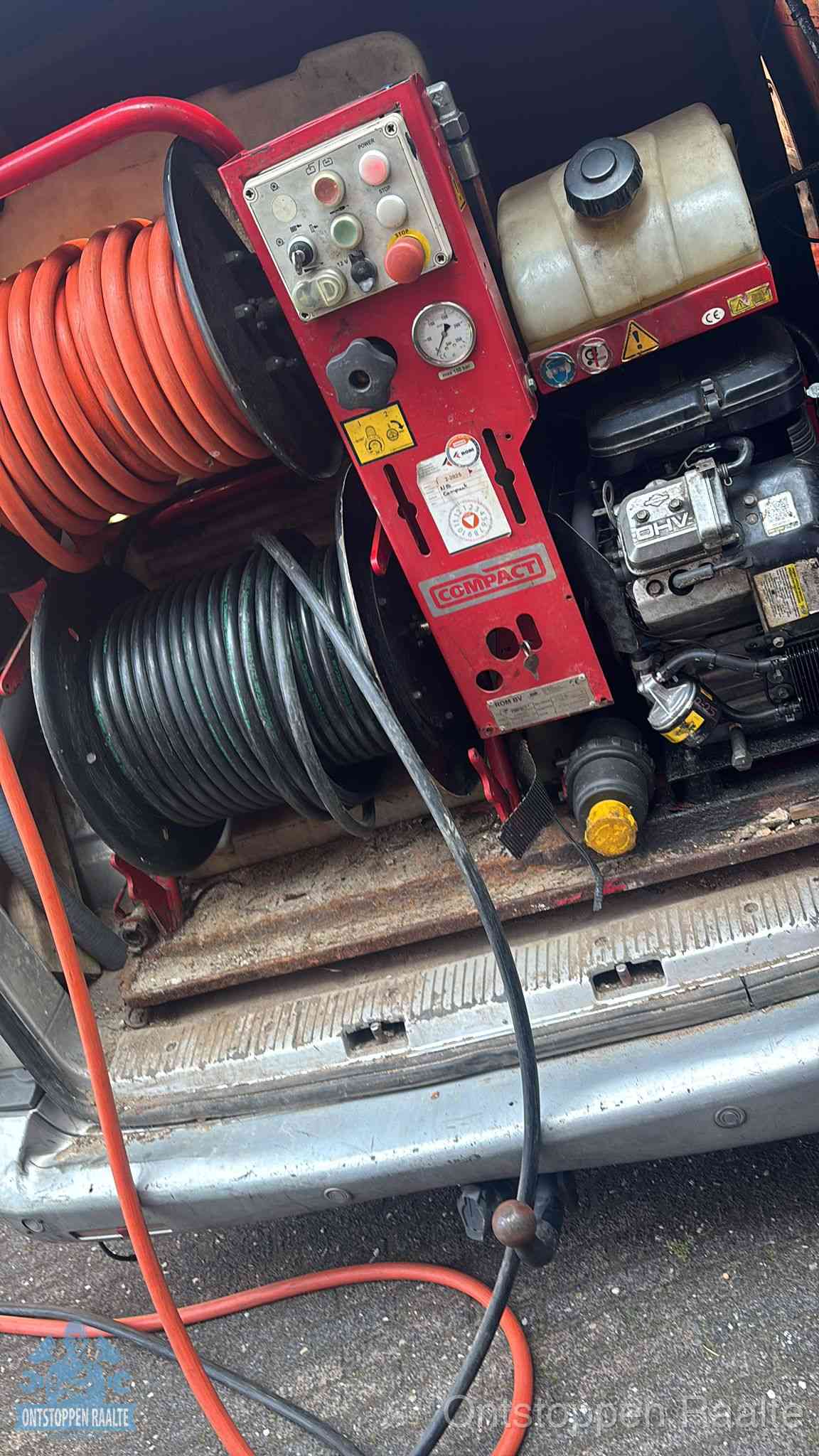 Een rood hogedruk-rioolreinigingstoestel met slangen in de laadbak van de bedrijfsbus, apparatuur voor een hardnekkige wc-verstopping in Raalte