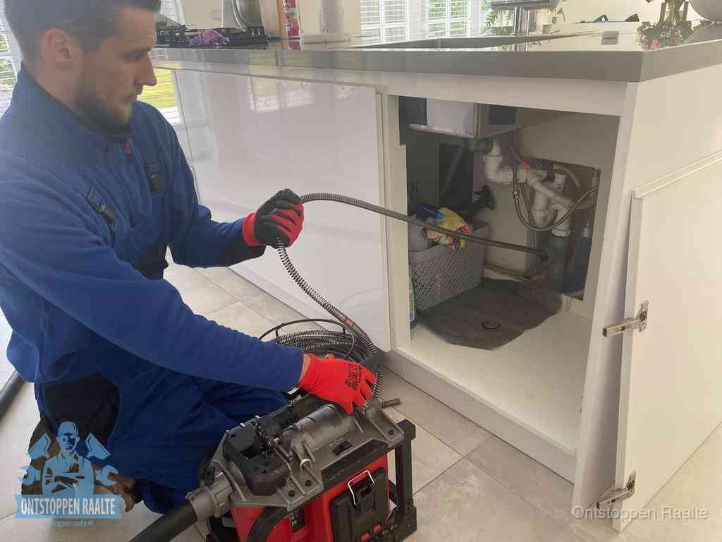 Een monteur reinigt de keukenafvoer grondig met een veermachine om terugkerende gootsteenverstoppingen te voorkomen in Raalte